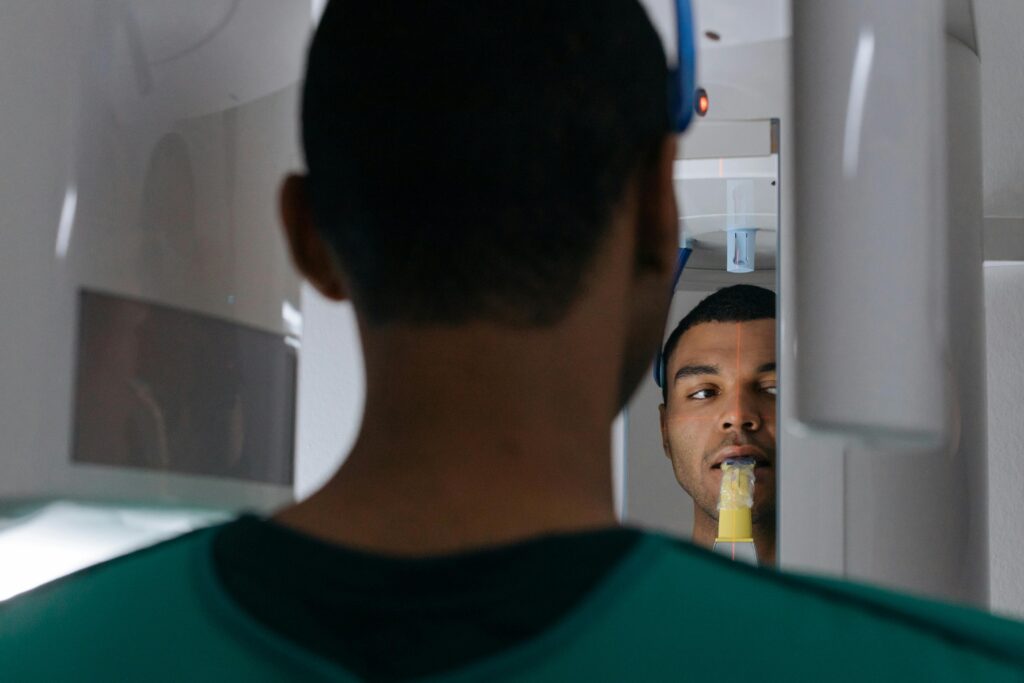 A man in a clinic receiving a dental X-ray scan as part of a checkup.